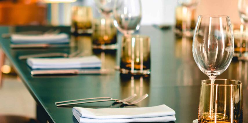 Empty glasses, plate, fork, knife on the table served for dinner in the modern restaurant